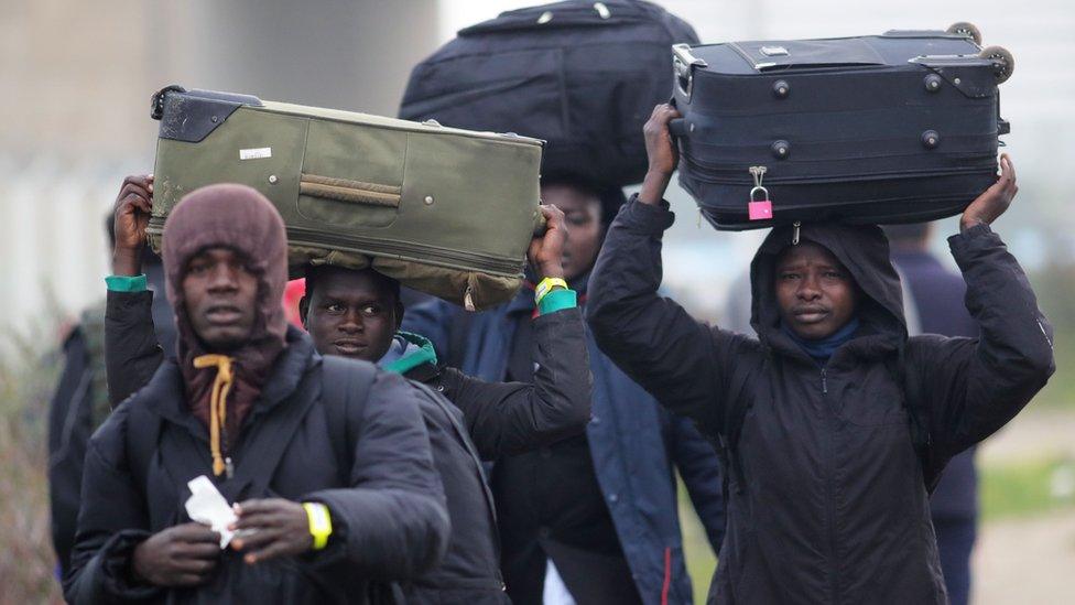 Refugees with their belongings leave migrant camp in Calais as French authorities move in to demolition the site on 24 October, 2016.