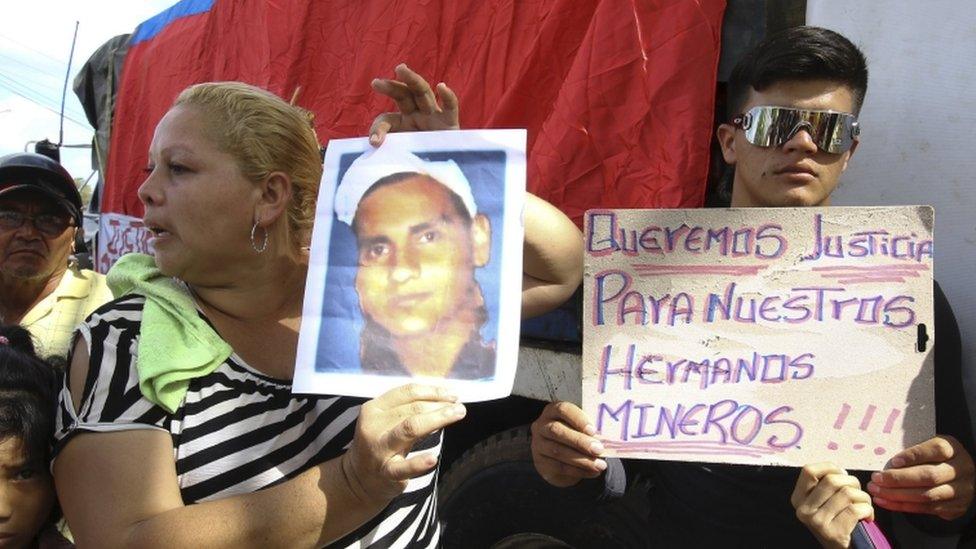 "We want justice for our miner brothers," reads the sign held at a demonstration in Tumeremo.