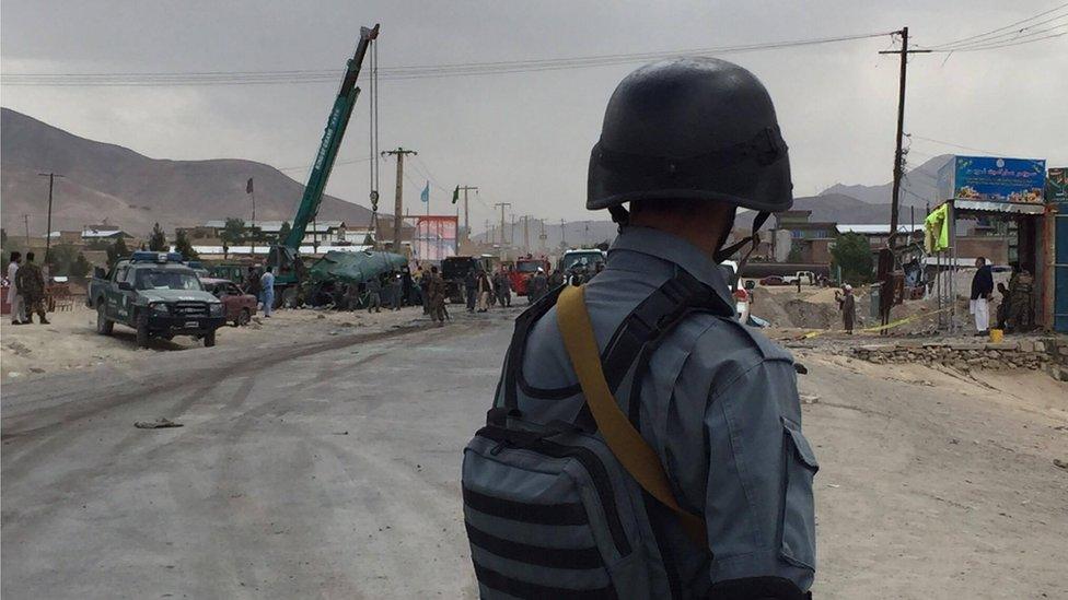 A soldier looks on as one of the busses is being lifted by a crane, near Kabul 30 June 2016