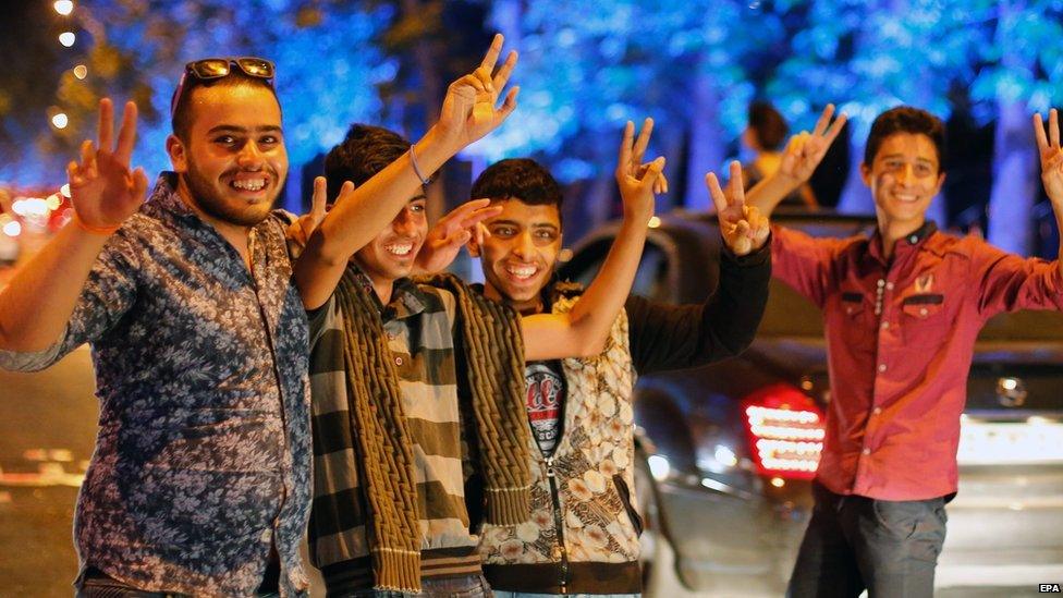 Iranians flash the victory sign as they celebrate in the street of Tehran, Iran, 14 July 2015