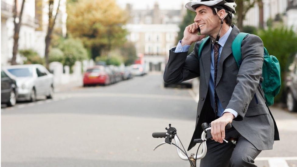 Stock photo of person using a mobile phone while using a bicycle