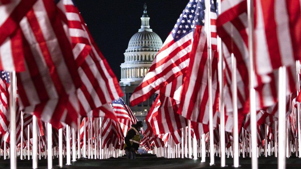 American flags in focus before the Whitehouse.