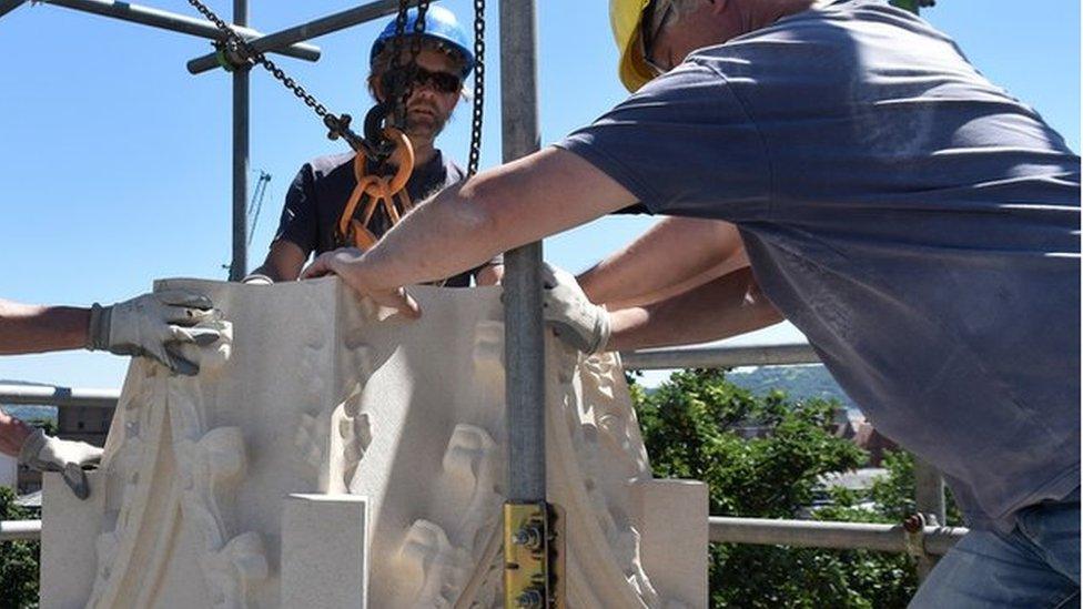 Stonemason lifting a pinnacle