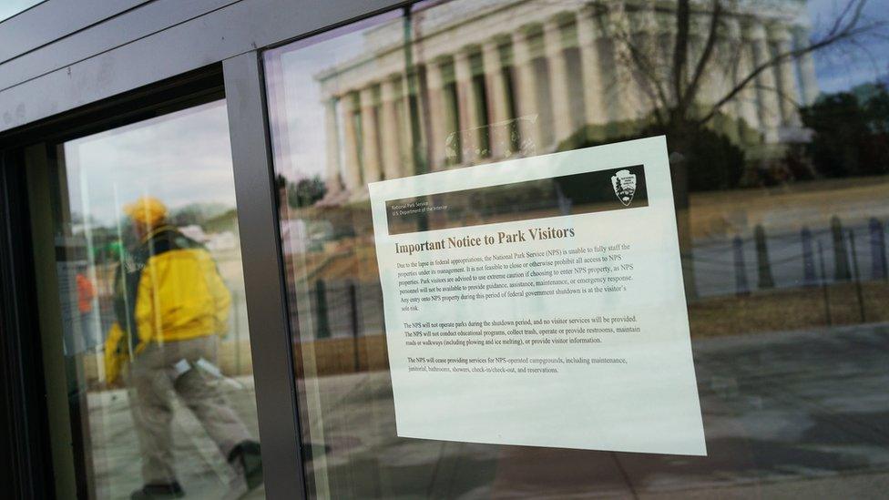 An image of the Lincoln Memorial is reflected onto a window of an information kiosk with a notice regarding the government shutdown in Washington, DC on January 22, 2018.