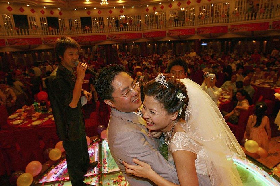 A couple hug during feast at a wedding ceremony on 6 May 2006 in Nanchang of Jiangxi Province, China.