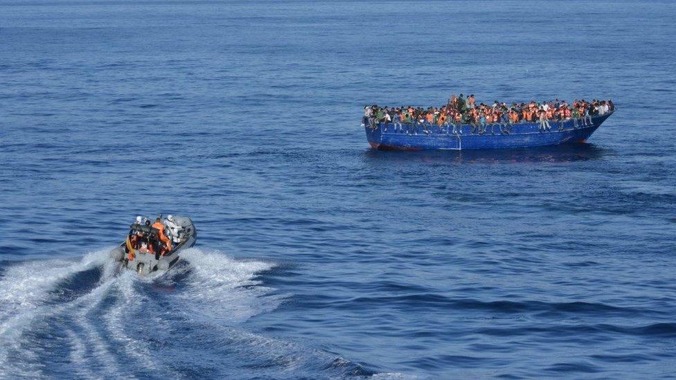 Spanish rescuers approaching a boat with migrants off the coast of Libya