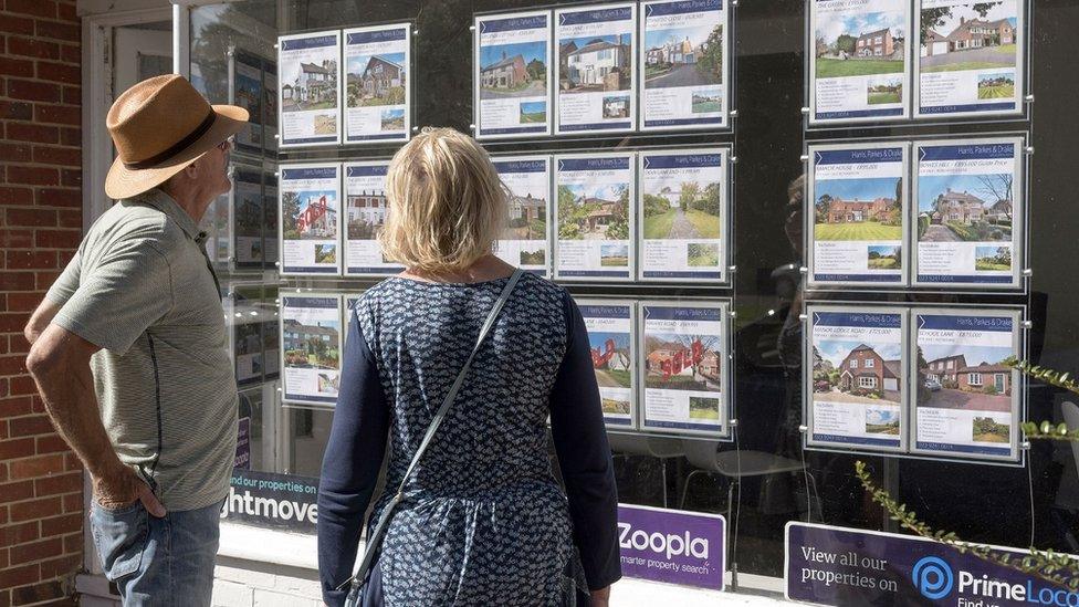 People looking in estate agent window