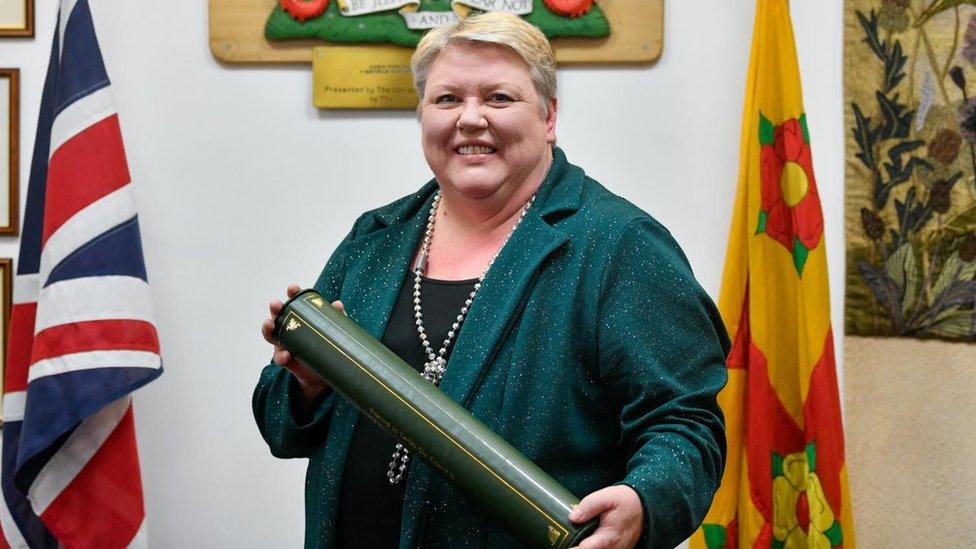 Val holds a green tube containing her honour