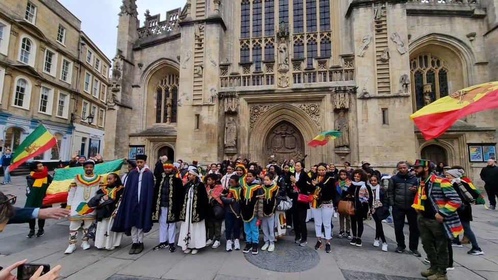 People standing outside Bath Abbey with Ethiopian flags