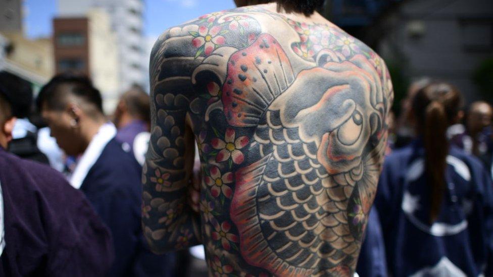 Participant with Japanese tattoo is seen in the street of Asakusa during Sanja Festival on May 19, 2019 in Tokyo, Japan