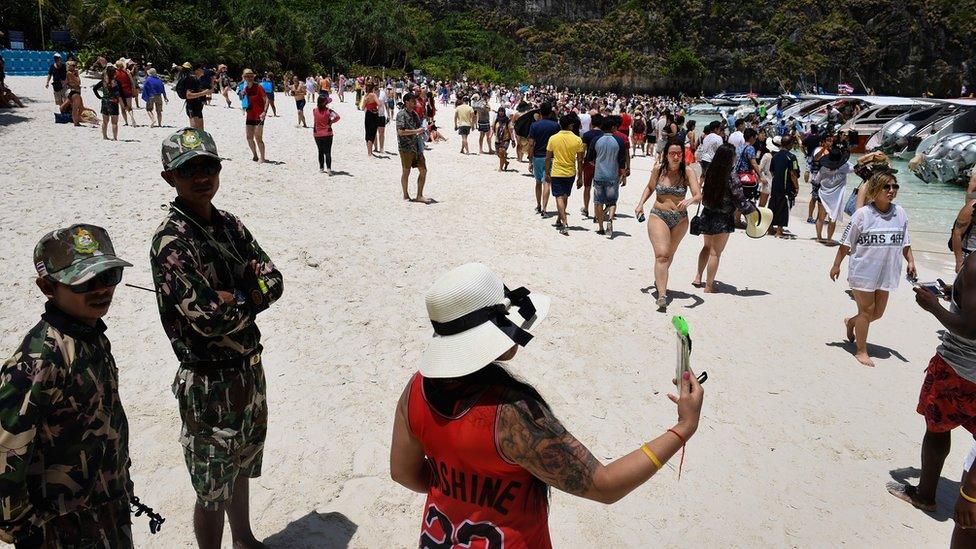 Thai park rangers keeping watch as tourists walk along the Maya Bay beach, Thailand, 9 April 2018