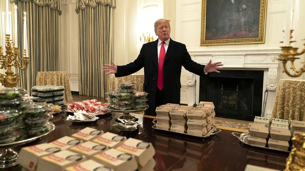 US President Donald Trump presents fast food to be served to the Clemson Tigers football team