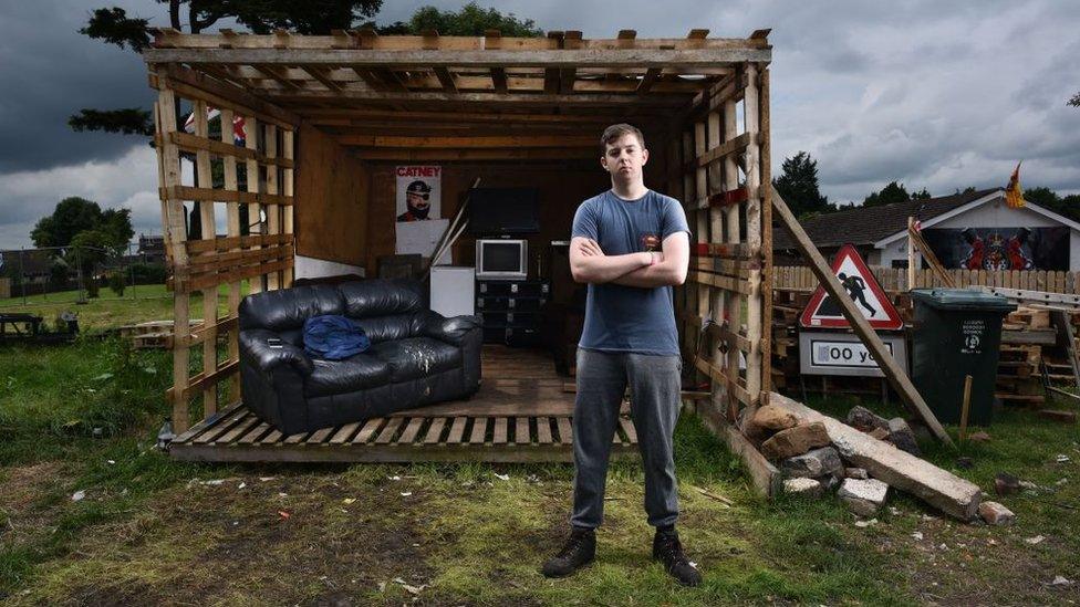 Reece Moore stands guard over the Ballymacash bonfire in his makeshift hut which is manned twenty fours hours a day on July 10, 2017 in Ballymacash, Northern Ireland.