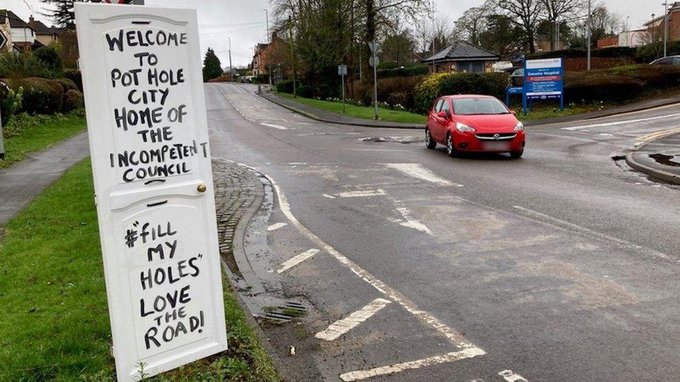 Pot Hole City - home of the incompetent council sign by a roundabout leading to a hospital