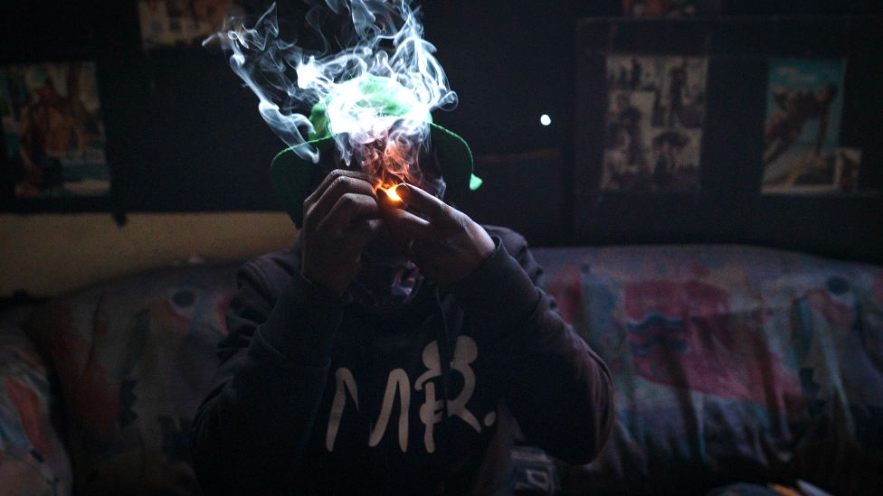 An unknown man smokes mandrax, a sedative crushed and smoked in a broken bottle head mixed with marijuana in the derelict San Jose building in Johannesburg, South Africa