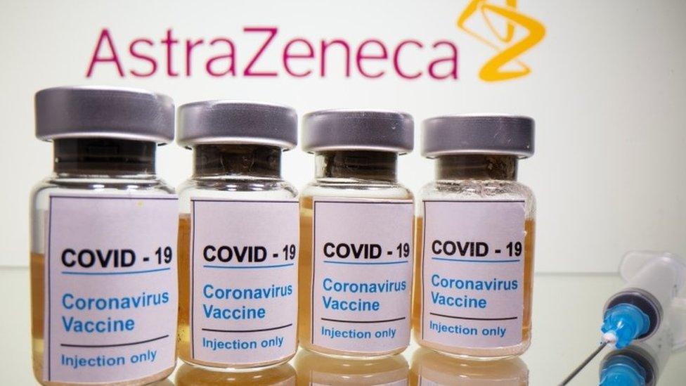 Vials with a sticker reading, "COVID-19 / Coronavirus vaccine / Injection only" and a medical syringe are seen in front of a displayed AstraZeneca logo in this illustration taken October 31, 2020.