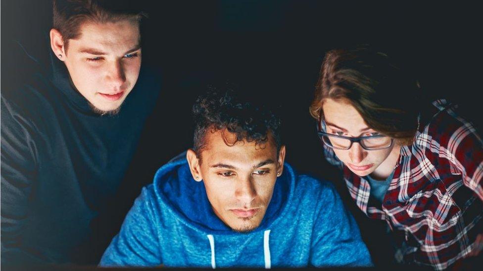 Young people looking at computer screen