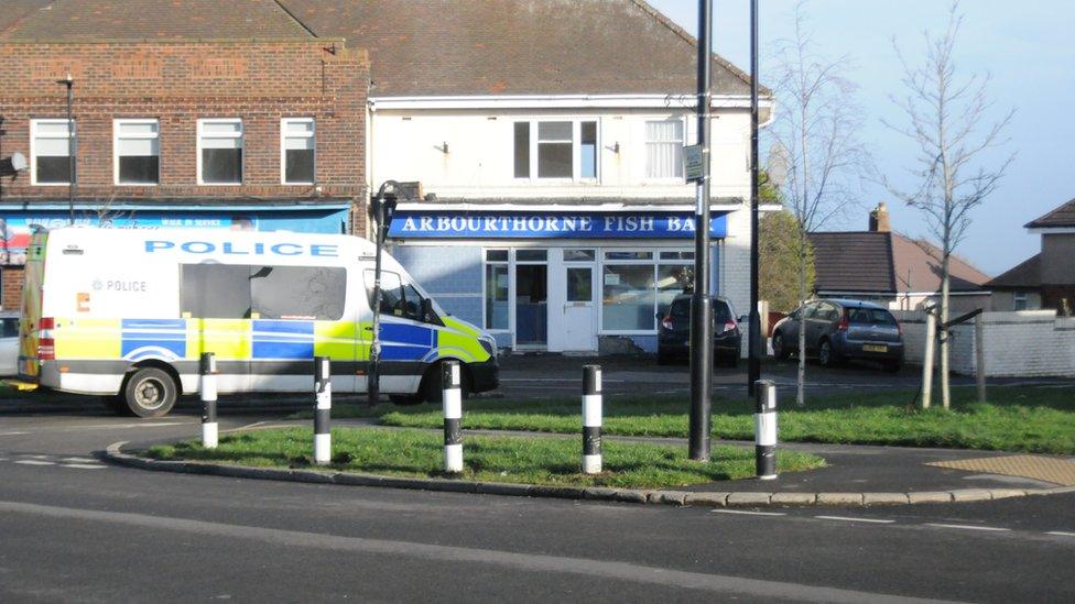 Police van in front of shops