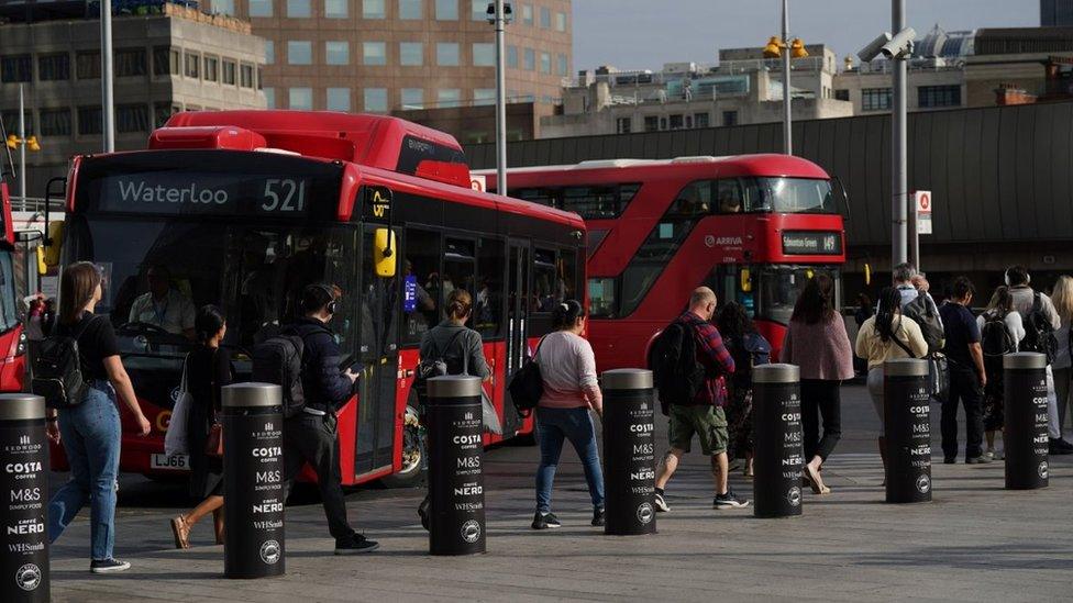 Commuters in a queue waiting for a bus at London Bridge station t