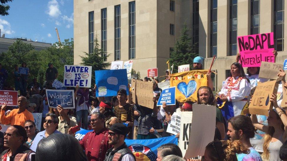 Protesters gather outside the US District Court while awaiting a judge's decision on whether to issue an injunction against the construction of the Dakota Access pipeline.