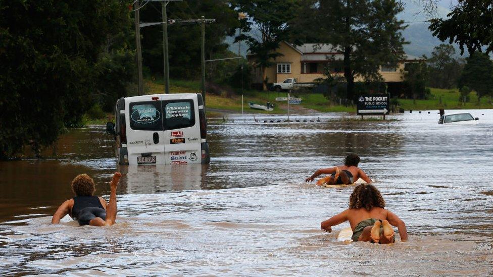 Residents in Billinudgel, NSW, used surf boards to paddle down the street.