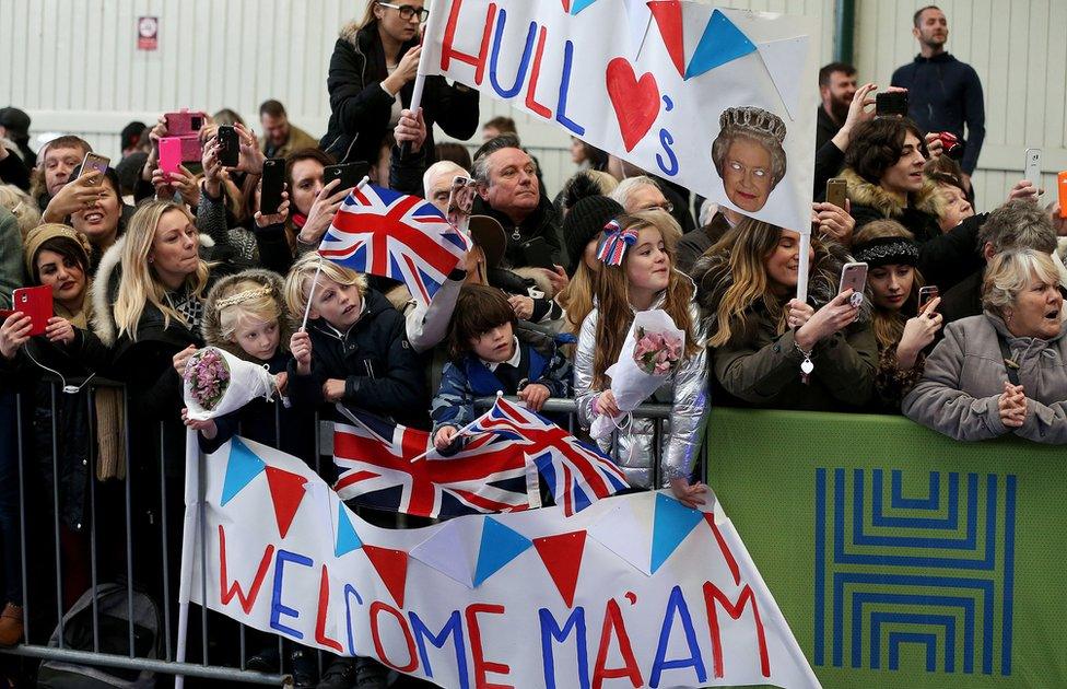 People cheering and waving banners and flags