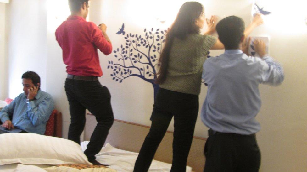 Three workers renovating a hotel room