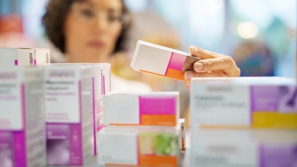 Woman looks at medicine in a cabinet