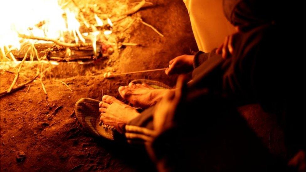 A Mexican man warms himself near a fire as temperatures dropped below freezing in Ciudad Juarez