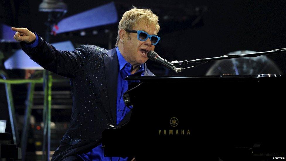 British singer-songwriter Elton John performs with his band during a concert in Gijon, July 17, 2015