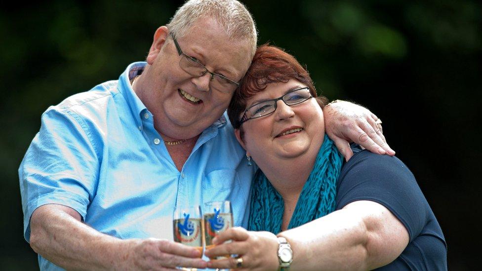 Colin Weir (L) and his wife Chris pose for pictures with champagne during a photocall in Falkirk, Scotland, on July 15, 2011, after winning a record GBP161m (