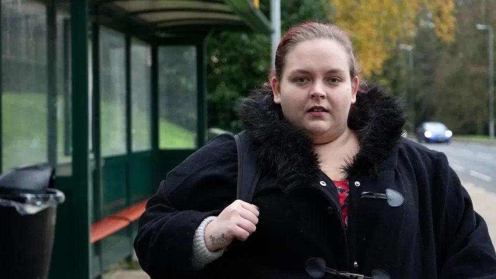 Lauren Matthews next to a bus stop close to their home in Ipswich