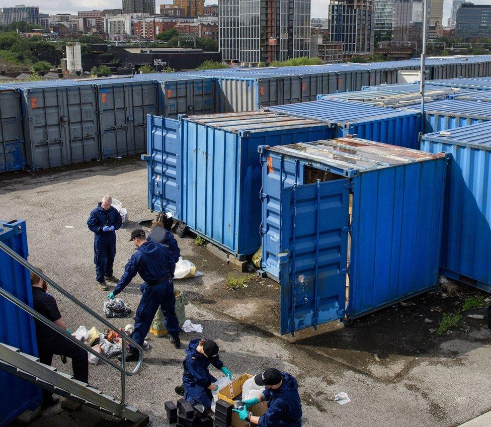 Police officers seize counterfeit goods from shipping containers