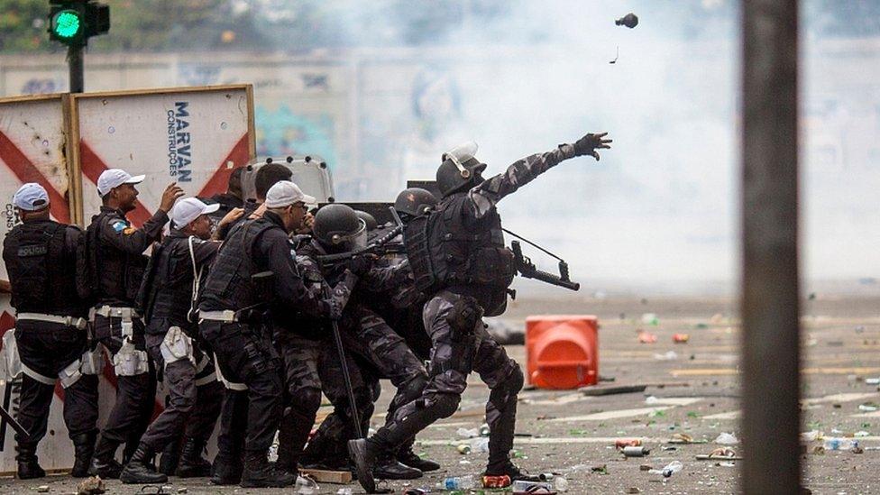 Riot police disperse fans of Flamengo football club taking part in a celebration parade