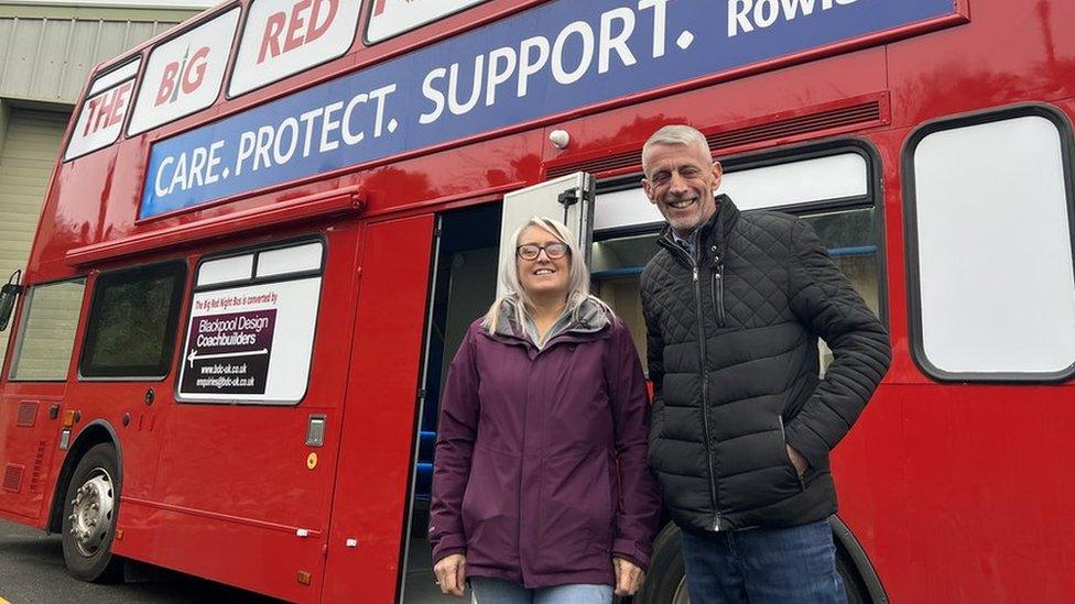 Abbie and Mark Butcher stood next to bus