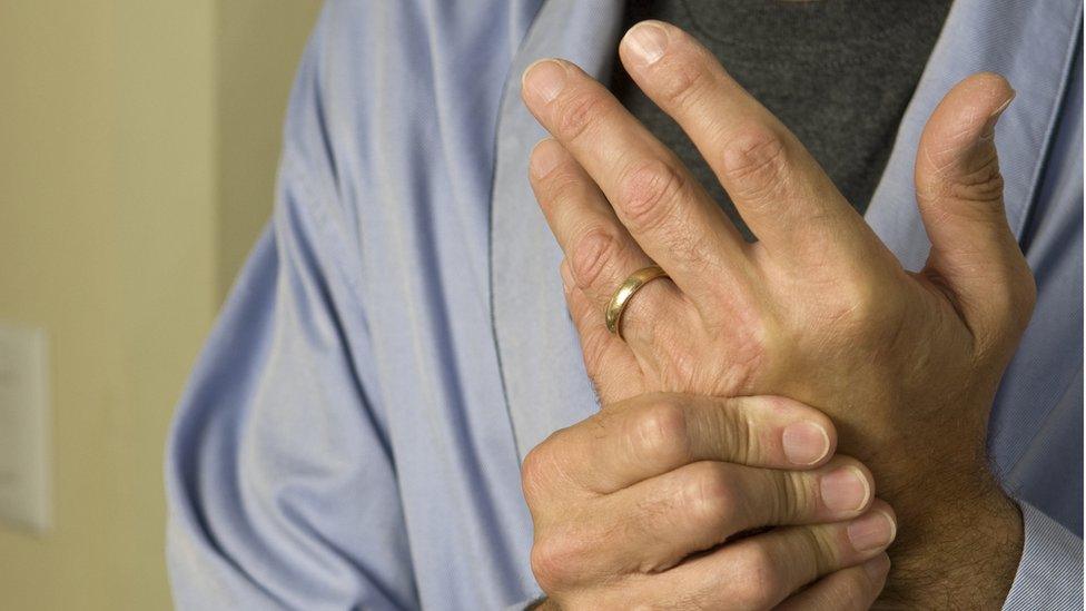 Man wringing his hands in pain