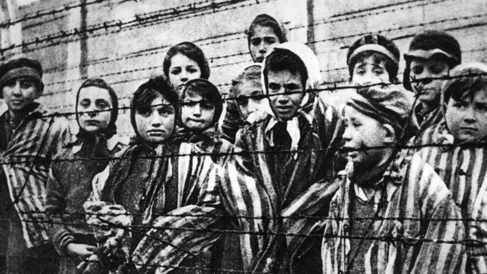 Children behind a barbed wire fence at the Nazi concentration camp at Auschwitz in 1945