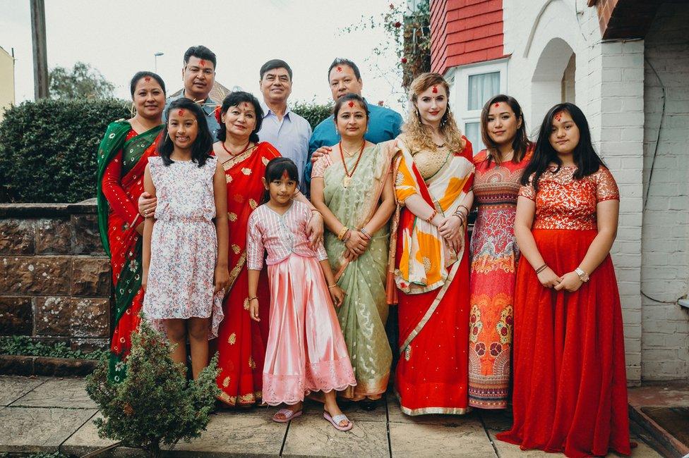 Portrait of a family posing outside their house