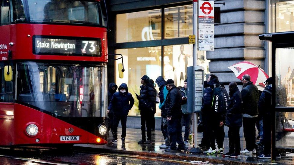 Commuters queuing for a bus