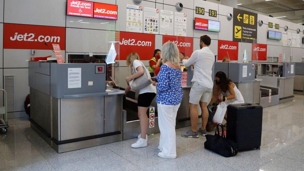 Passengers queue up at the Jet2 check-in desk at Palma de Mallorca airport in Mallorca