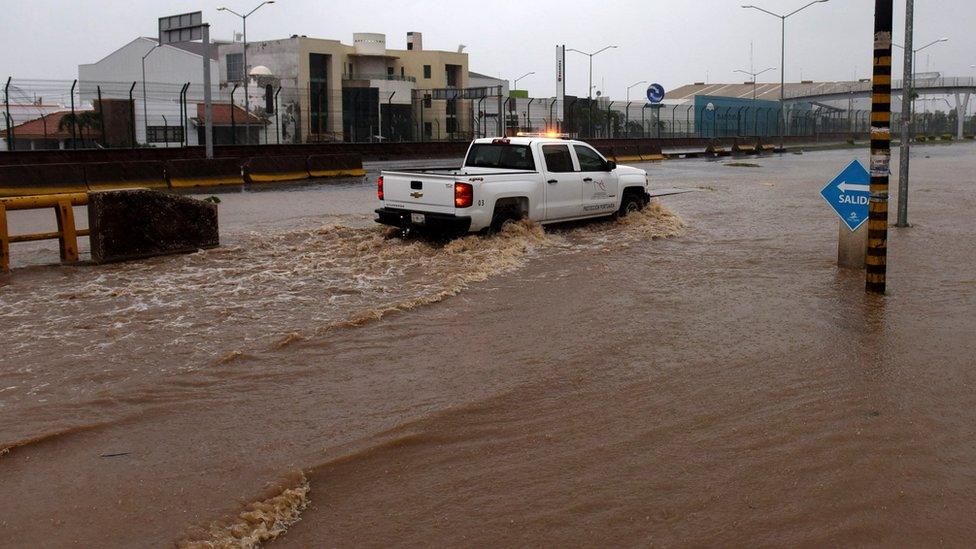 A truck drives along a flooded street in Manzanillo, Colima state, Mexico on 23 October 2015