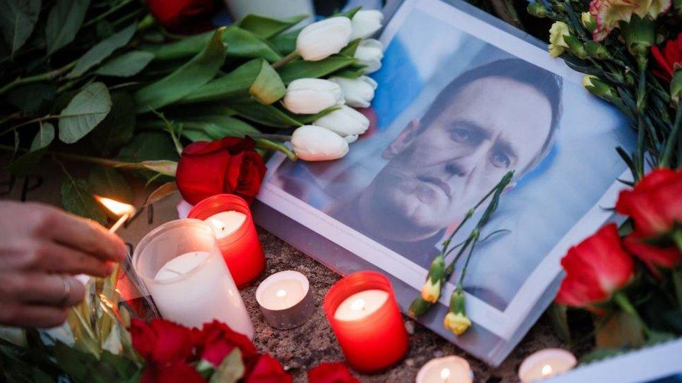 A picture of Russian opposition leader Alexei Navalny is seen surrounded by candles at a memorial to him following the news of his death