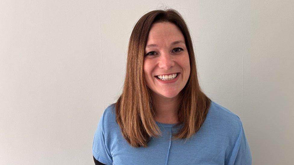 Headteacher Katy Hanna smiling into the camera wearing a blue top