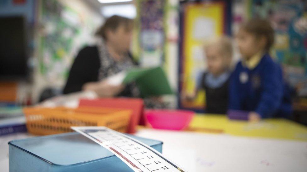 School children and a primary teacher blurred