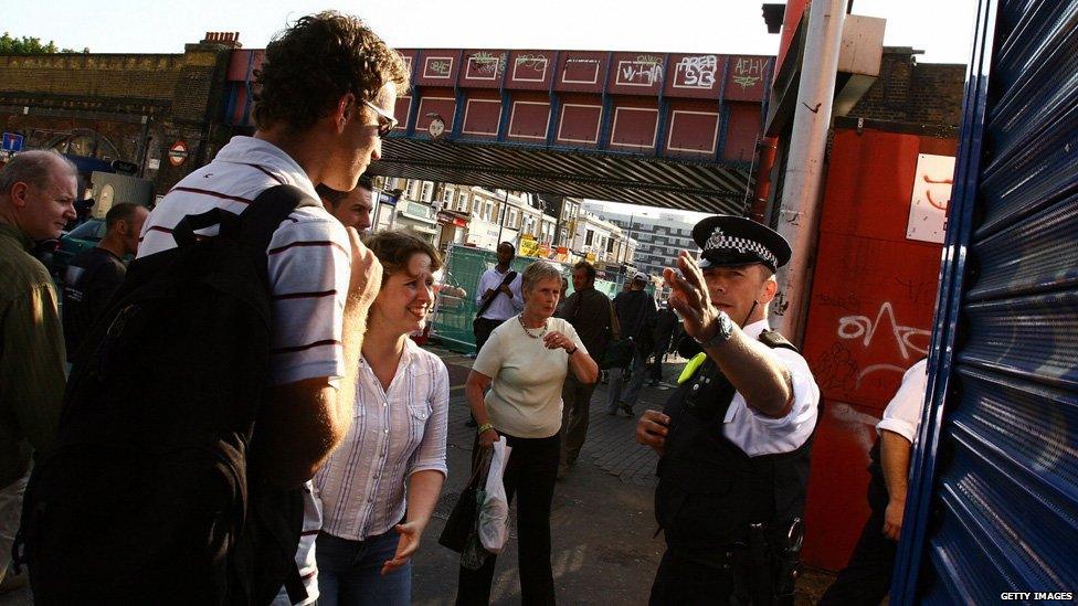 A police officer directs people, 21 July 2005, as they try to make their way home near Shepherds bush tube station in London