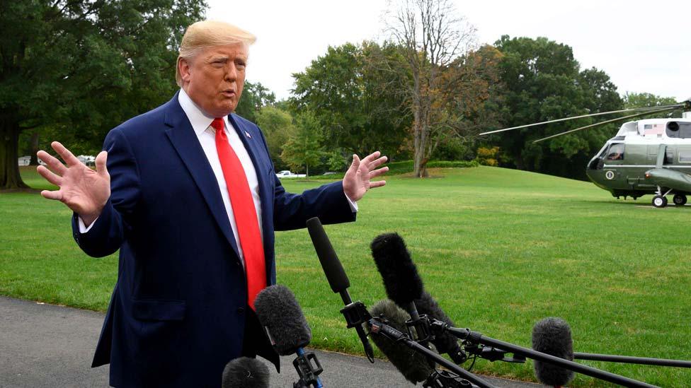 President Trump gives a thumbs-up to the cameras as he arrives back at the White House on Thursday