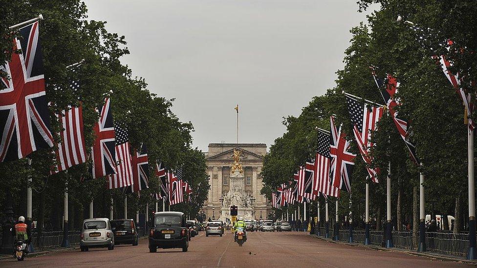 The national flags of Britain and the US fly on the Mall in London