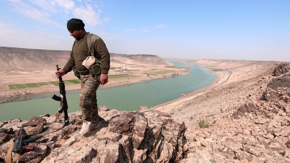 A Syrian Democratic Forces (SDF) fighter poses for a picture near Euphrates River, north of Raqqa city, Syria March 8,