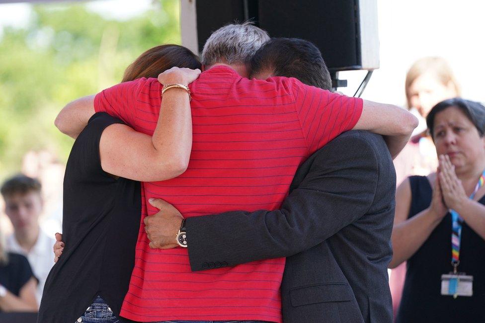 Grace O'Malley-Kumar's father (right) and Barnaby Webber's parents embrace during a vigil at the University of Nottingham