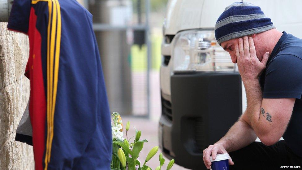 A fan reflects on the death of Adelaide Crows coach Phil Walsh at the club's headquarters in Adelaide, South Australia, 3 July, 2015